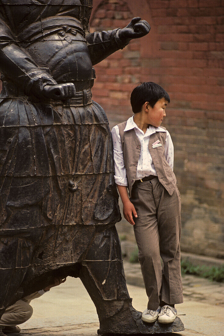Wächterstatuen, Song Shan,Kind neben Tempelwächter aus Gußeisen im im Vorhof des Kloster Zhongyue, taoistischer Tempel,  Zhongyue, daoistisch-buddhistischer Berg Song Shan, Provinz Henan, China, Asien
