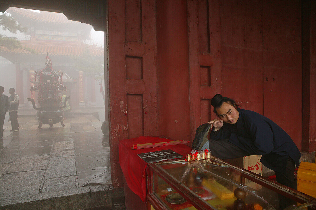 Taoist monk at the entrance to Bixia Si temple doing stretching exercises, Azure Clouds Temple, Mount Tai, Tai Shan, Shandong province, World Heritage, UNESCO, China