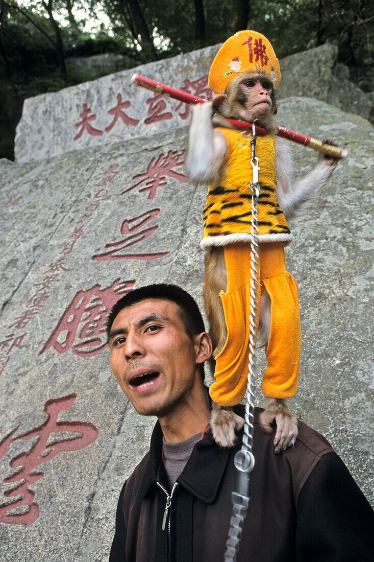 Man with performing monkey, Monkey is dressed up as the monkey king Sun Wukong, Mount Tai, Tai Shan, Shandong province, World Heritage, UNESCO, China