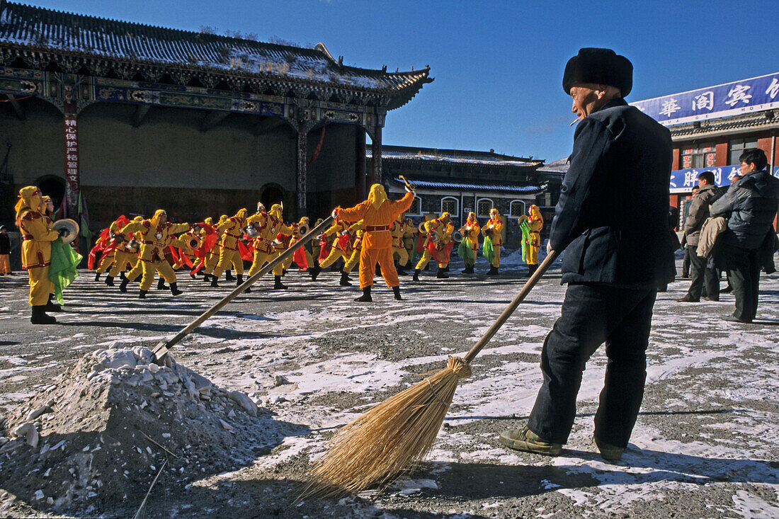 dance group and street sweeper, Chinese new year, Rehearsal, Wutai Shan, Five Terrace Mountain, Buddhist centre, town of Taihuai, Shanxi province, China, Asia