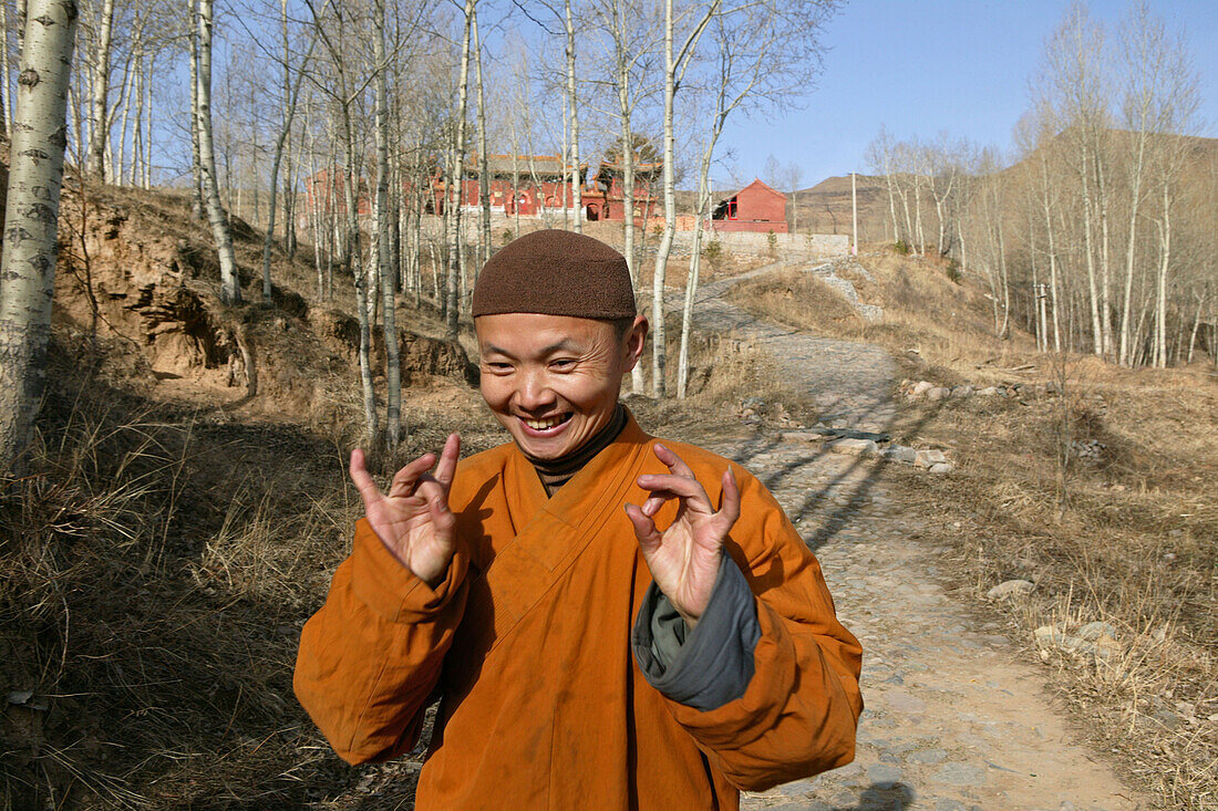 Monk demonstrating prayer posture on his to Santa Monastery, Mount Wutai, Wutai Shan, Buddhist holy Mountain, Shanxi province, China