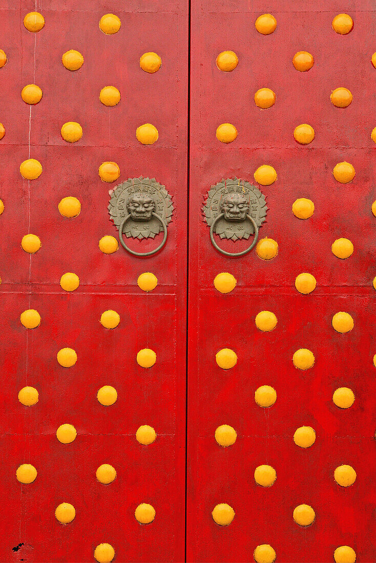 temple door, gate, double doors in red with round yellow decorations, lion door knockers, China, Asia