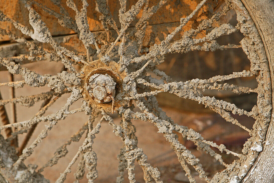 Wheel spokes of a cart caked with dried mud, China