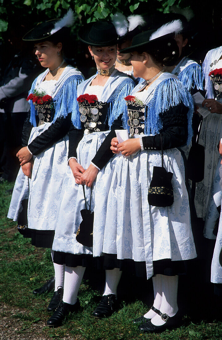 Three young women in dirndl dresses talking to each other, pilgrimage to Raiten, Schleching, Chiemgau, Upper Bavaria, Bavaria, Germany