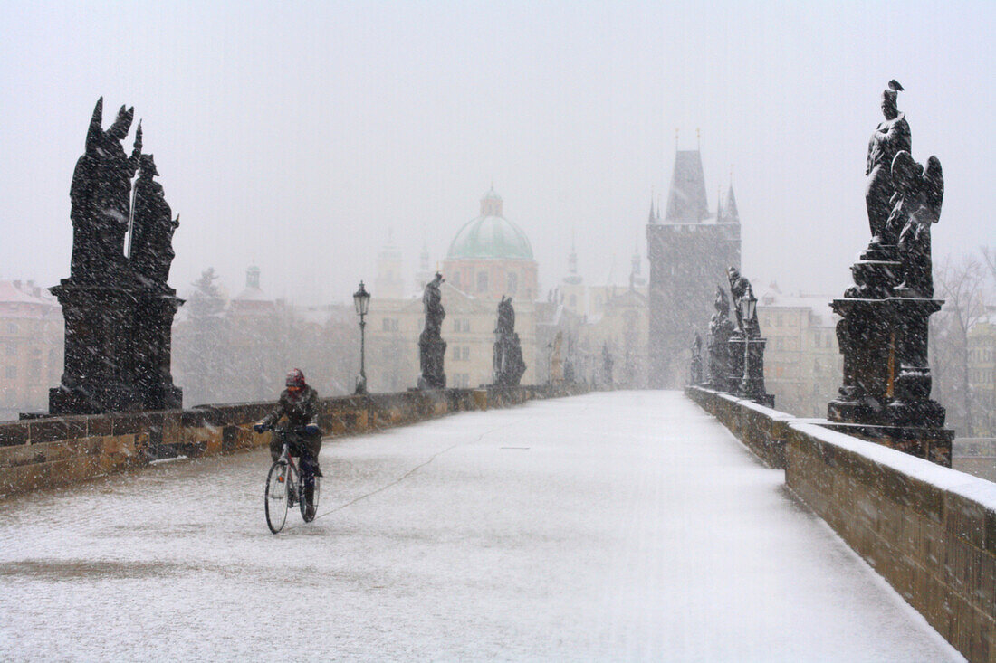 Mann fährt Fahrrad über Karlsbrücke, Prag, Tschechien