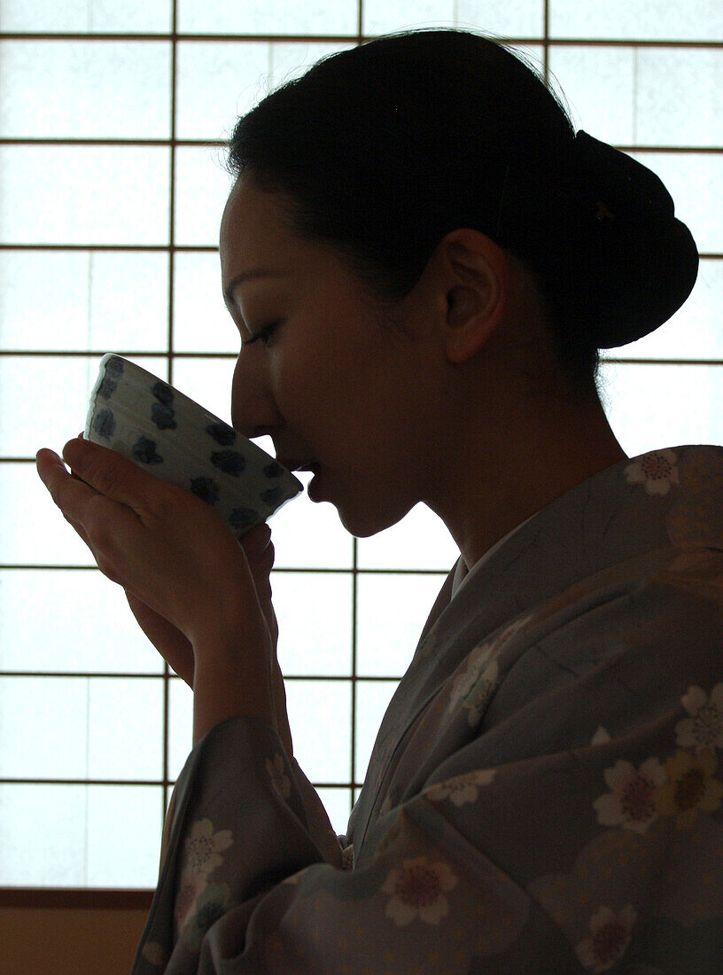 Japanische Frau trinkt Tee, Teezeremonie in Hosomi Museum, Kyoto, Japan
