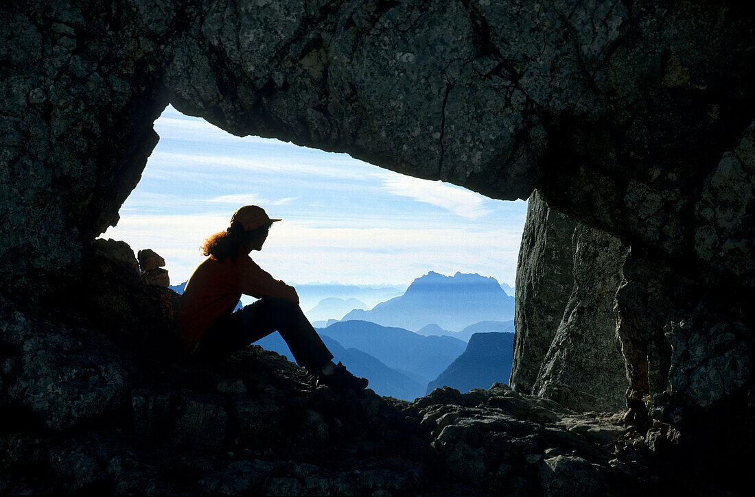 Felsentor mit Bergsteigerin mit Blick auf Wilden Kaiser, Mayerbergscharte, Reiteralm, Berchtesgadener Alpen, Oberbayern, Bayern, Deutschland