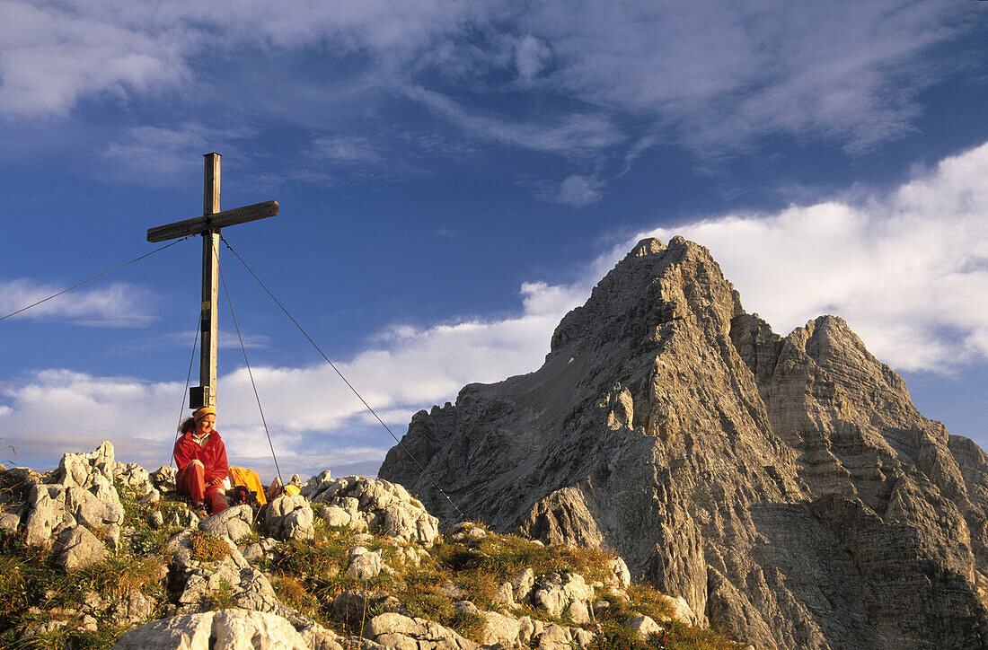 Mountaineer and summit cross with a view of the Watzmann, Berchtesgaden Range, Upper Bavaria, Bavaria, Germany