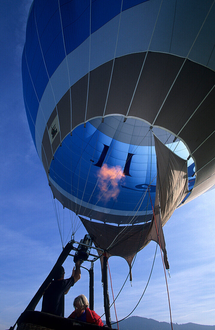 Start zu Ballonfahrt, Heizen des Heissluftballons mit Passagieren in der Gondel, Bad Tölz, Oberbayern, Bayern, Deutschland