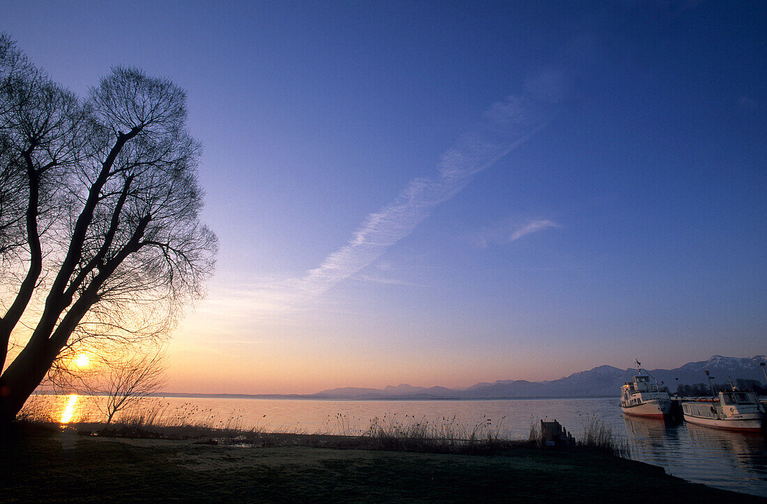 Sonnenaufgang in Gstadt am Chiemsee mit Booten der Chiemseeschifffahrt, Chiemgau, Oberbayern, Bayern, Deutschland