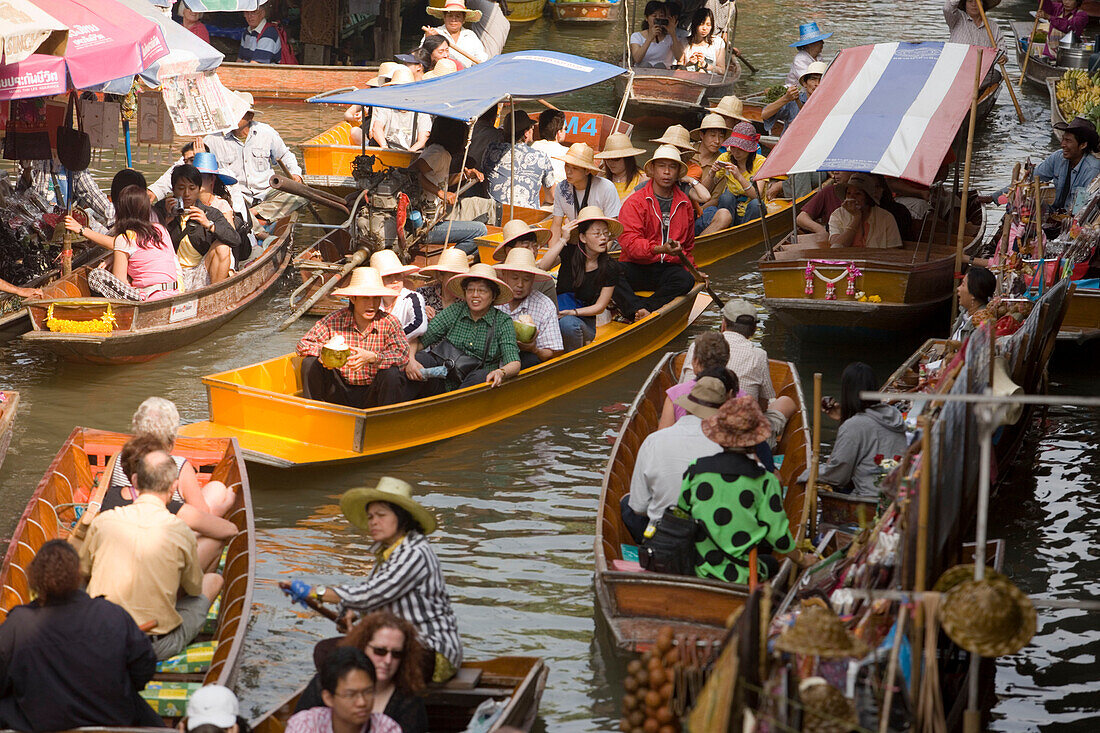 Tourists in a wooden boat visiting the Floating Market, Damnoen Saduak, near Bangkok, Ratchaburi, Thailand