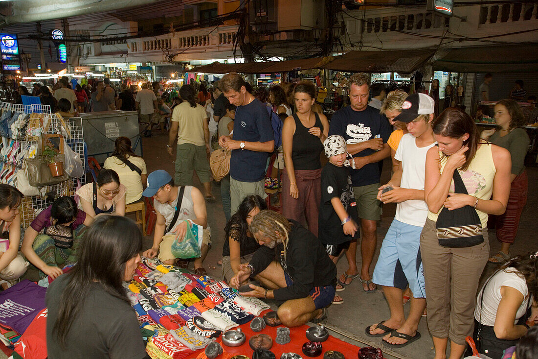 Tourists shopping at Th Khao San Road in the evening, Banglamphu, Bangkok, Thailand