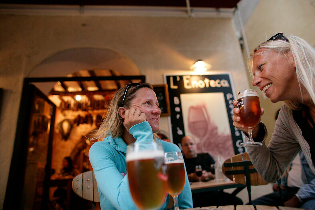 Two women drinking beer, street cafe, Bonifacio, Corse, France