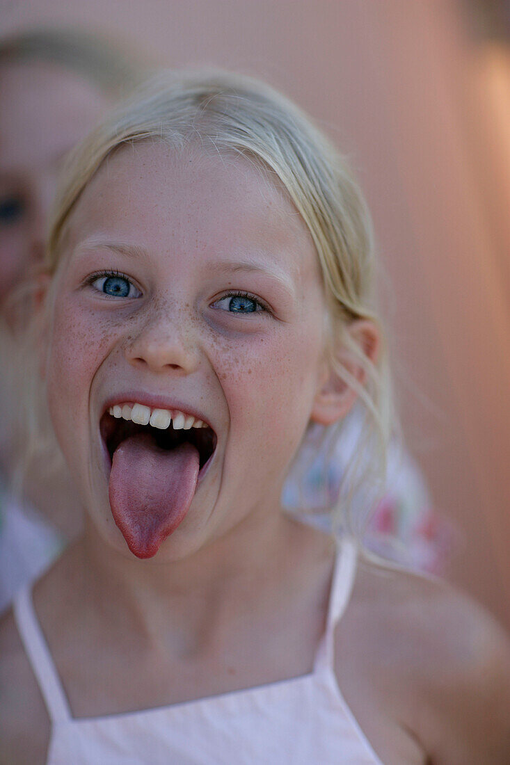 Girl (8 years) sticking out tongue, Portrait