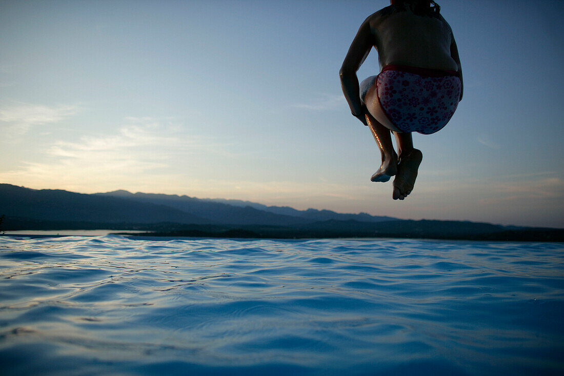 Mädchen springt in Pool, Bucht von Porto Vecchio, Südkorsika, Frankreich