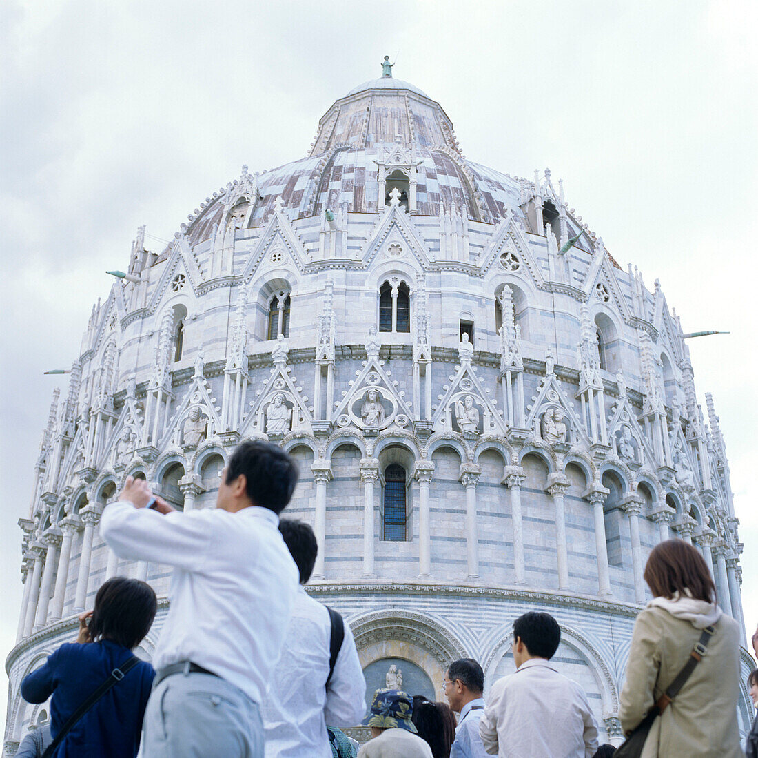 Asiatische Touristen vor dem Baptisterium in Pisa, Toskana, Italien