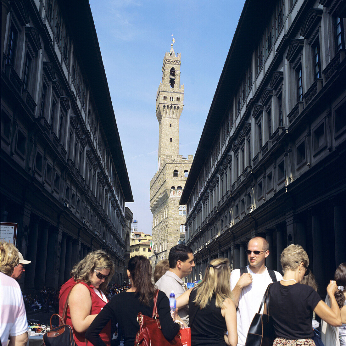 Menschen stehen in einer Schlange vor den Uffizien, im Hintergrund der Palazzo Vecchio, Florenz, Italien