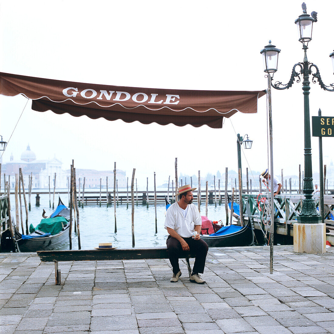 Ein Gondoliere sitzt auf einer Bank, Venedig, Italien