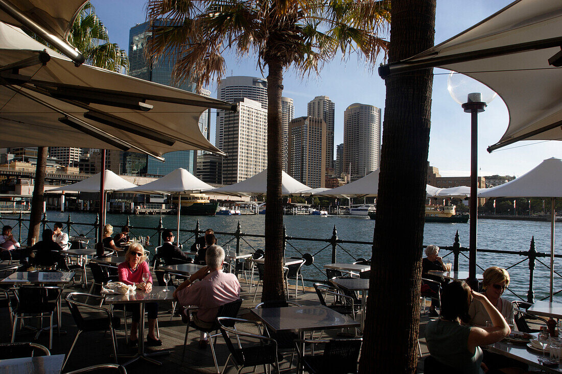 Tourists, bar, café, restaurant, open-air, Circular Quay, panorama, skyline of Central business district, CBD, harbour, port, Sydney Cove, state Capital of New South Wales, Sydney, Australia