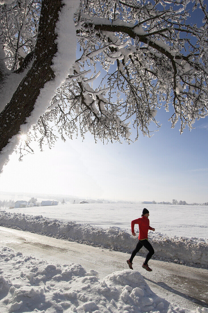 Ein Mann, Läufer, joggt im Winter, Oberösterreich, Austria