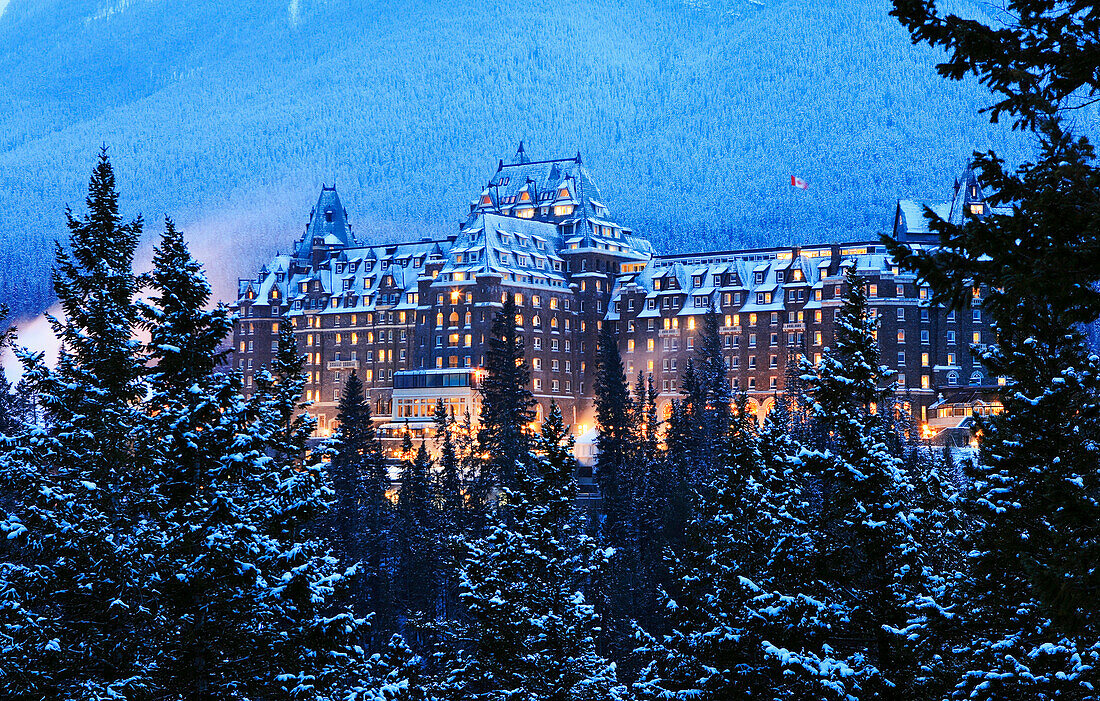A big house a building in the winter in the forest. Evening, Banff Fairmont Springs Hotel, Rocky Mountains, Alberta, Canada, North Amerika