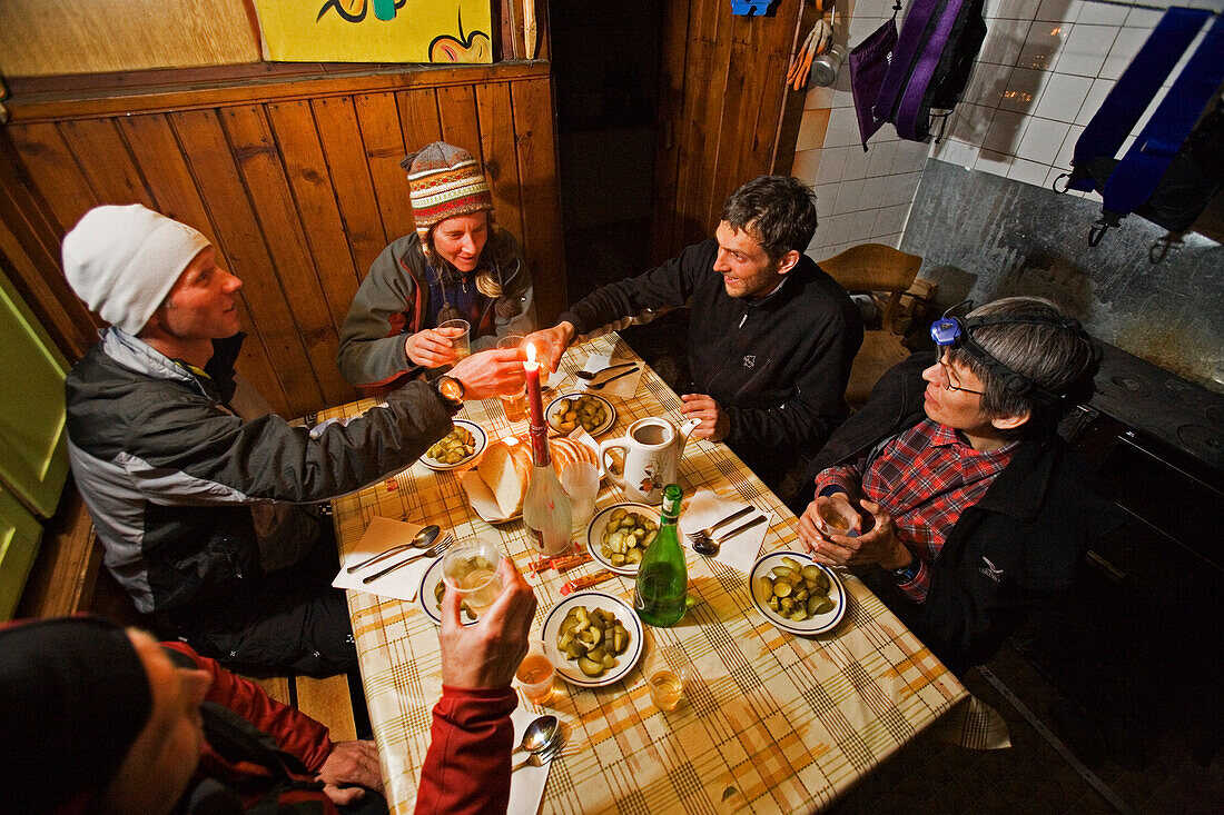 A group of people in a moutain hut toasts with a glass of Raki brandy, Demjanica cabin, Pirin Mountains, Bulgaria, Europe