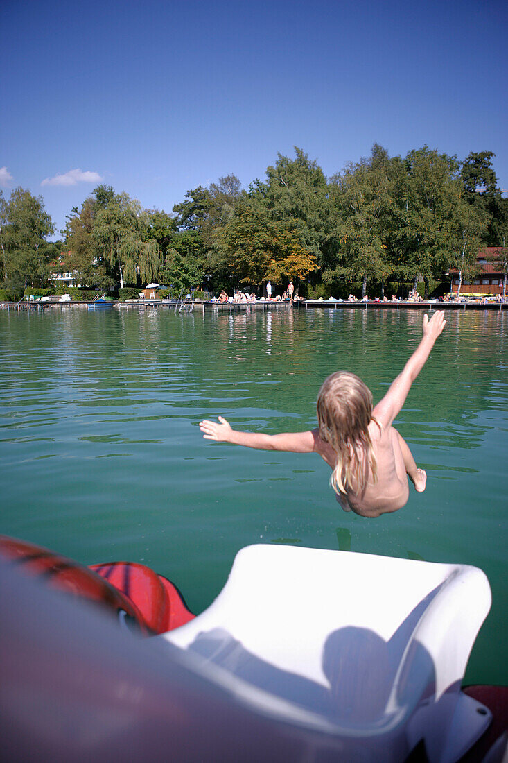Kind rutscht ins Wasser von einem Boot, Walchstadt, Wörthsee, Bayern, Deutschland