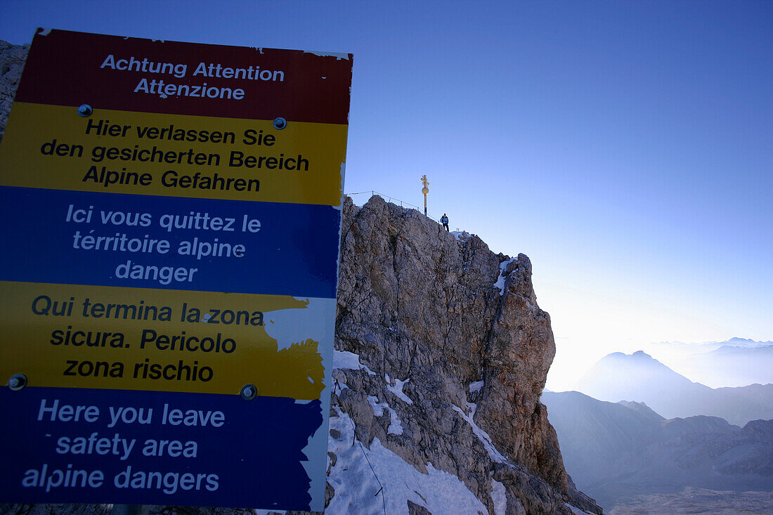 Warnschild und mann am Zugspitzgipfel, Zugspitze, Bayern, Deutschland