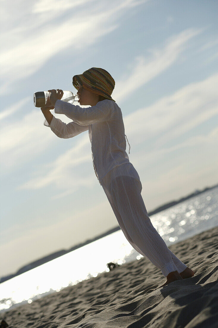 Girl drinking a bottle of water, Travemuende Bay, Schleswig-Holstein, Germany