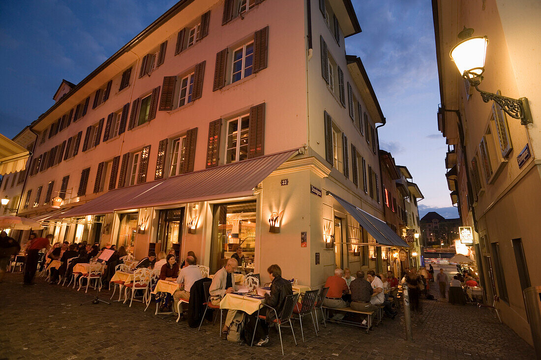 Guests sitting in a pavement cafe at a corner near Hirschplatz in the evening, Niederdorfstrasse, Zurich, Canton Zurich, Switzerland