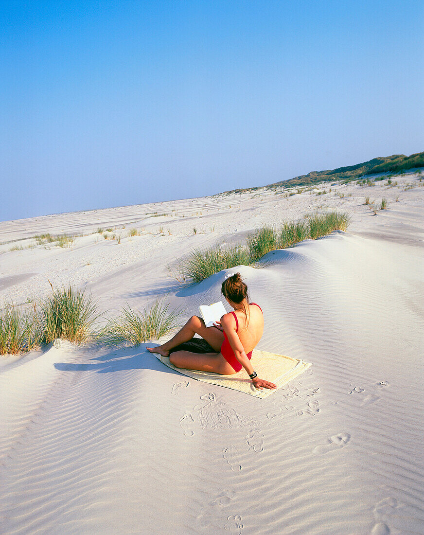 Woman reading on the beach, Spiekeroog Island, Lower Saxony, Germany