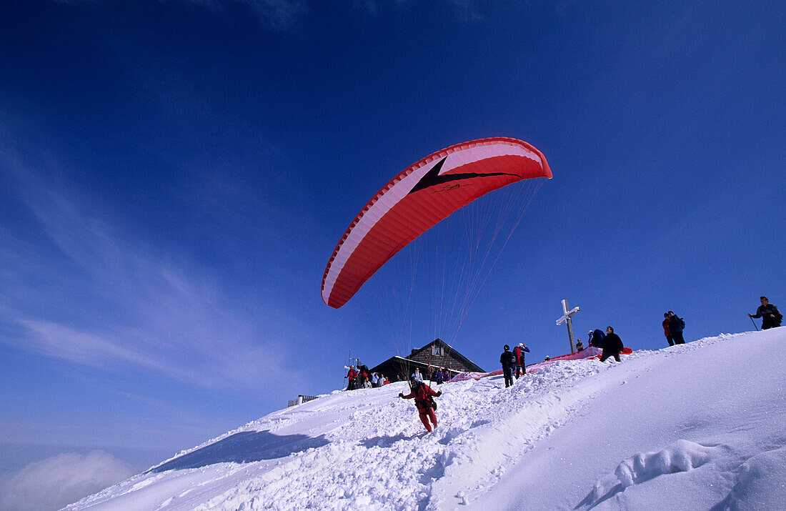 Gleitschirmflieger an der Hochries im Winter, Chiemgauer Alpen, Oberbayern, Bayern, Deutschland