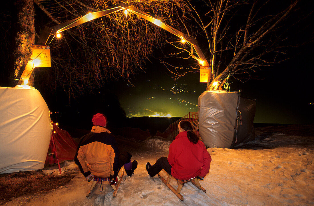 Two persons at start of illuminated toboggan-run, Nagelköpfel, Piesendorf, Salzburg, Austria