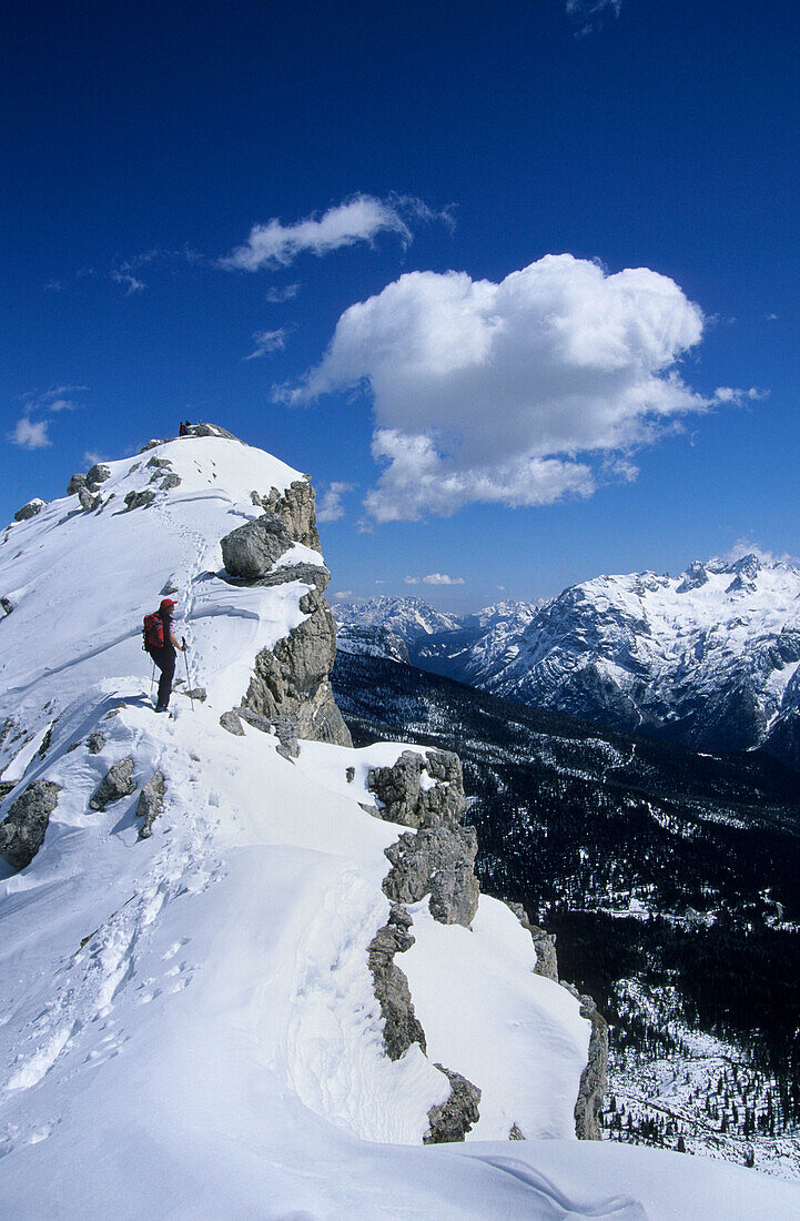 Backcountry skier on summit ridge of Corno d´Angolo, view to Marmarole range, Cristallo range, Dolomites, South Tyrol, Italy