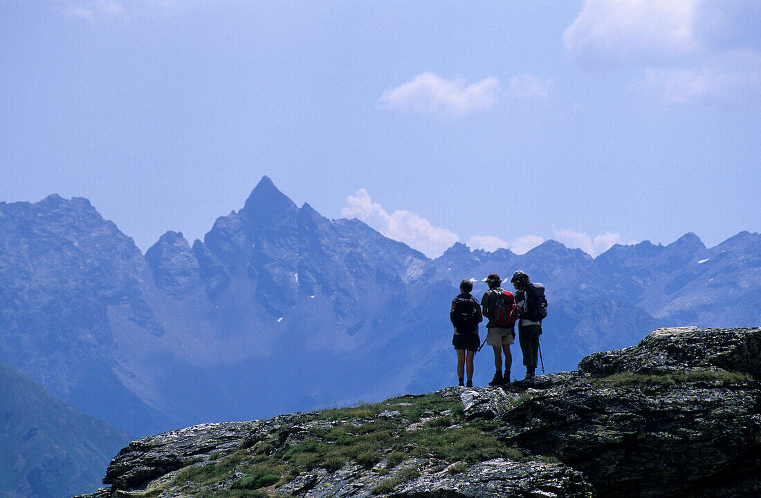 Three hikers with view to Piz dal Teo, Livigno Alps, Oberengadin, Grisons, Switzerland