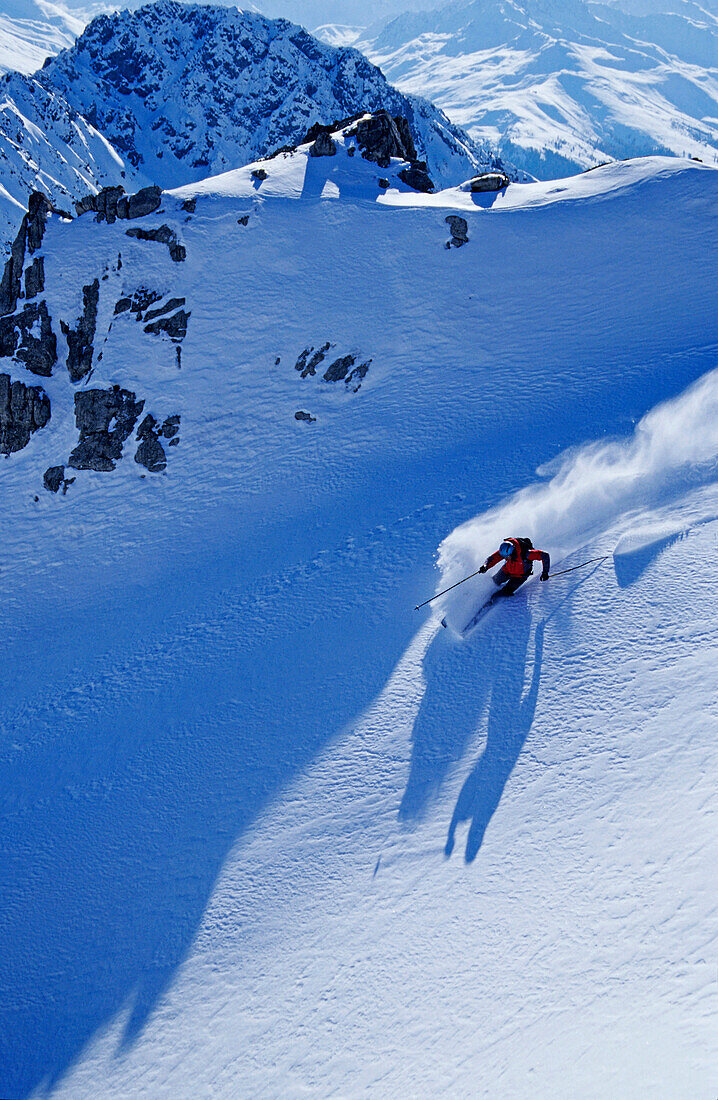 Ein junger Mann, ein Skifahrer, ein Freerider macht eine Kurve im Pulverschnee, Tiefschnee in Skigebiet Parsenn, Davos, Klosters, Graubünden, Graubuenden, Schweiz, Europa, Alpen