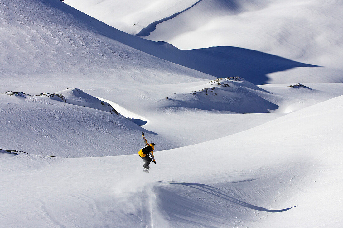 A young man, a snowboarder, makes a jump in powder snow at Saentis, Appenzell, St. Gallen, Toggenburg, East Switzerland, Switzerland, Alps