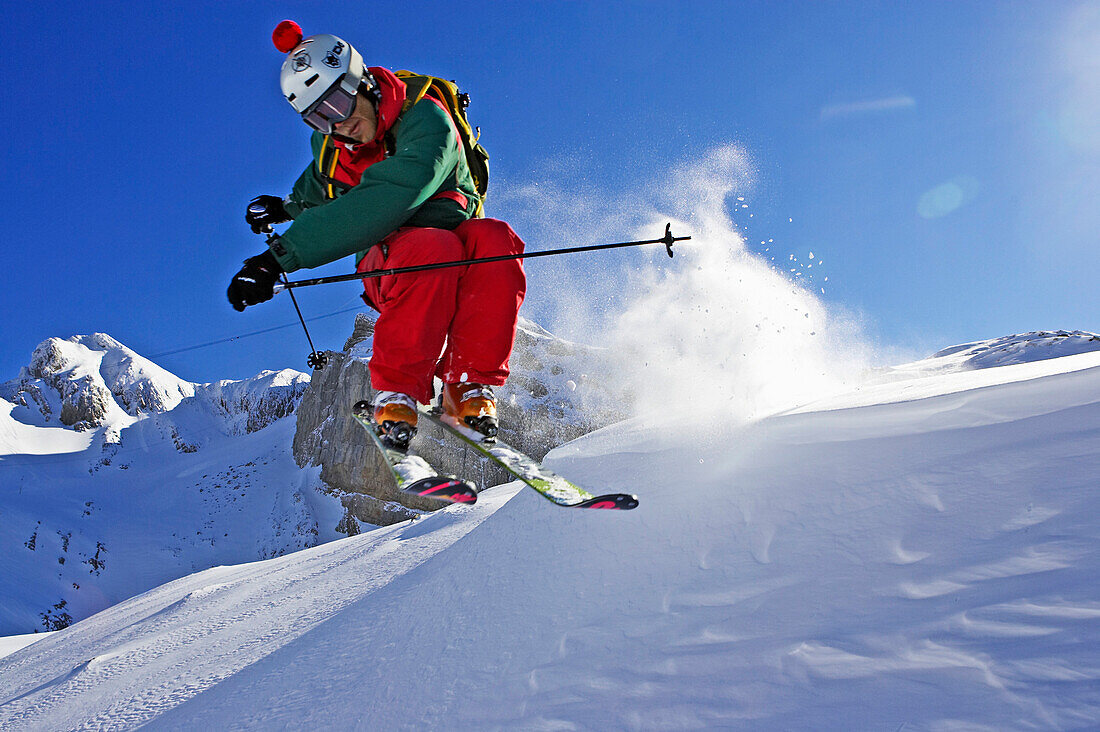 Ein junger Skifahrer, ein Freerider springt über eine Wächte während einer Abfahrt vom Säntis, Appenzell, St. Gallen, Toggenburg, Ostschweiz, Schweiz, Alpen