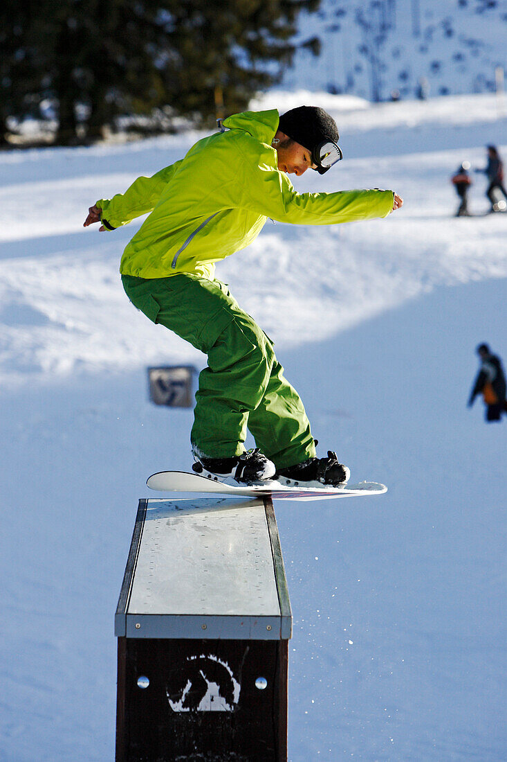 A young man on a snowboard makes a trick, a Backside Boardslide on an A-Frame Box at the funpark snowland, Wildhaus, Toggenburg region, East Switzerland, St. Gallen, Switzerland, Alps, Europe
