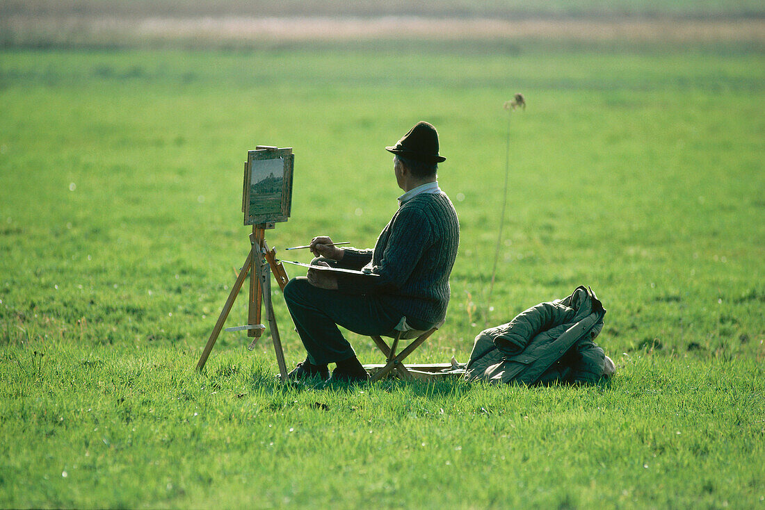 A man painting scenery near Breitbrunn, Lake Chiemsee, Upper Bavaria, Bavaria, Germany, Europe