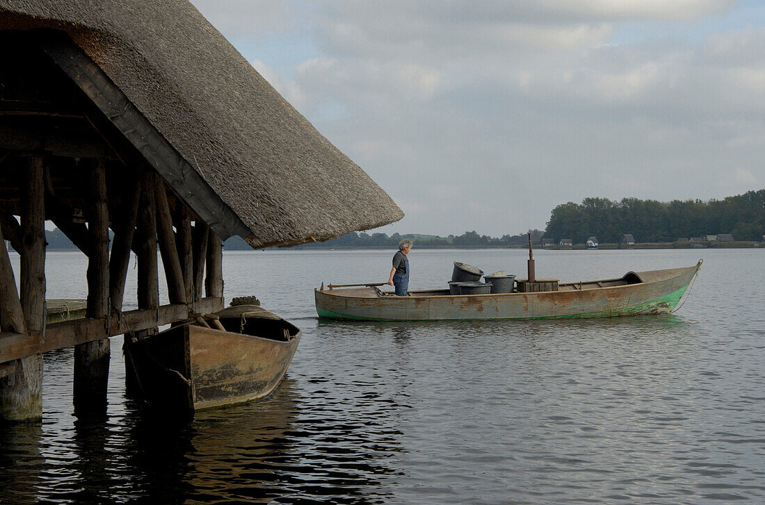 Man driving a boat on Lake Krakow, Mecklenburg-Western Pomerania, Germany, Europe