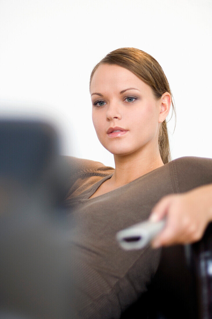 Young woman using remote control