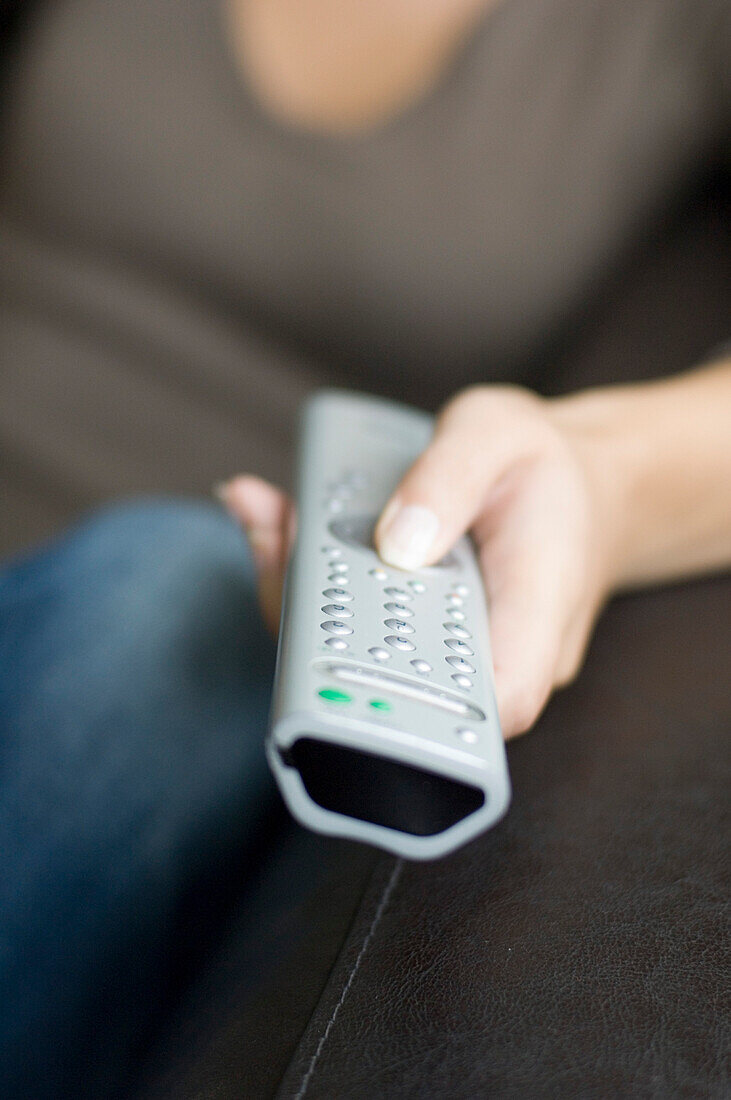 Young woman using remote control, close-up