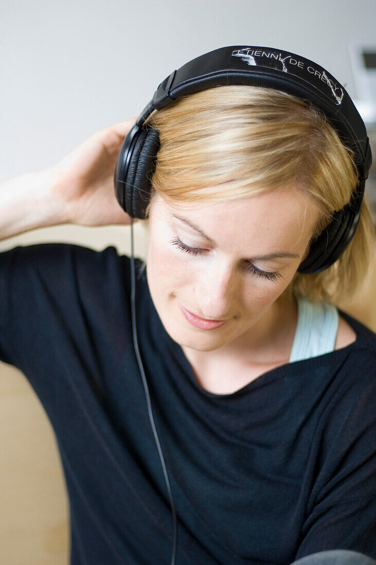 Young woman listening to music about earphones