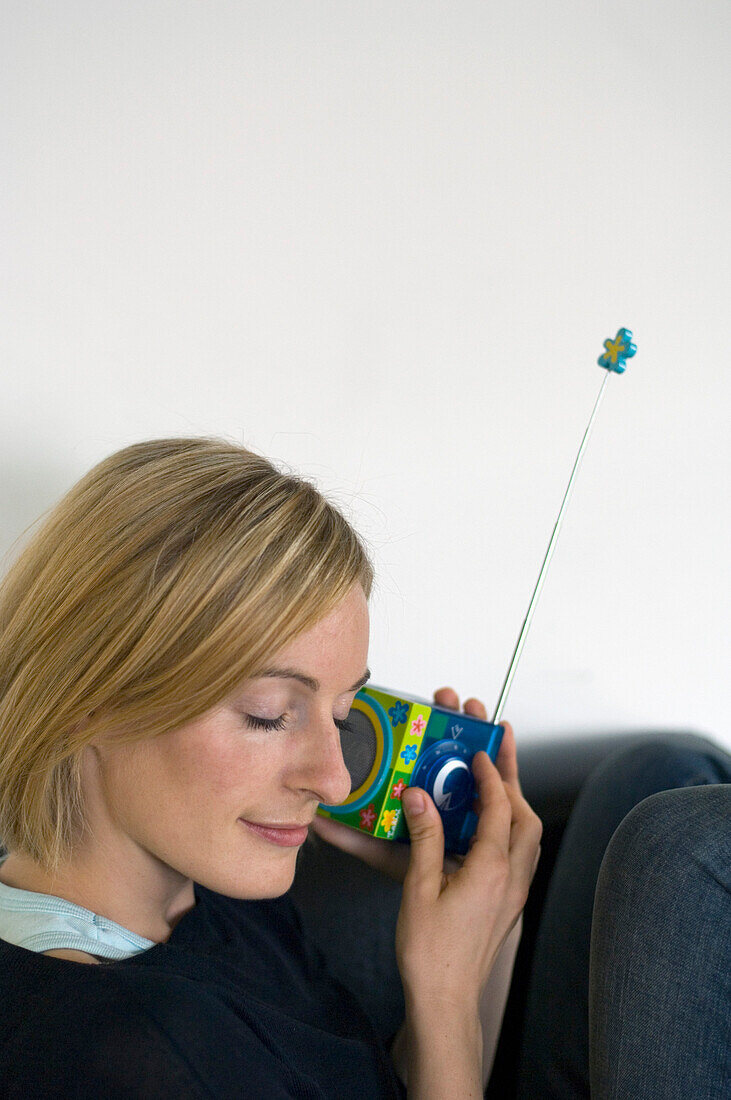 Young woman listening to portable radio