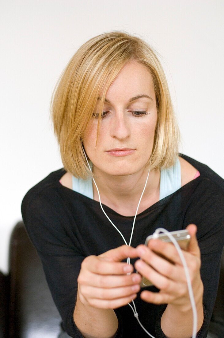 Junge Frau hört Musik über Kopfhörer