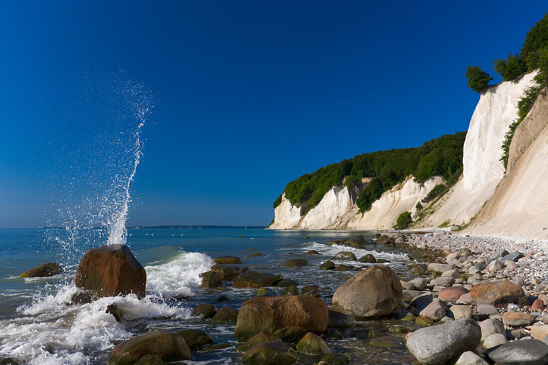 Waves splashing against rocks with chalk cliffs in the background, Jasmund National Park, Mecklenburg Western Pomerania, Germany