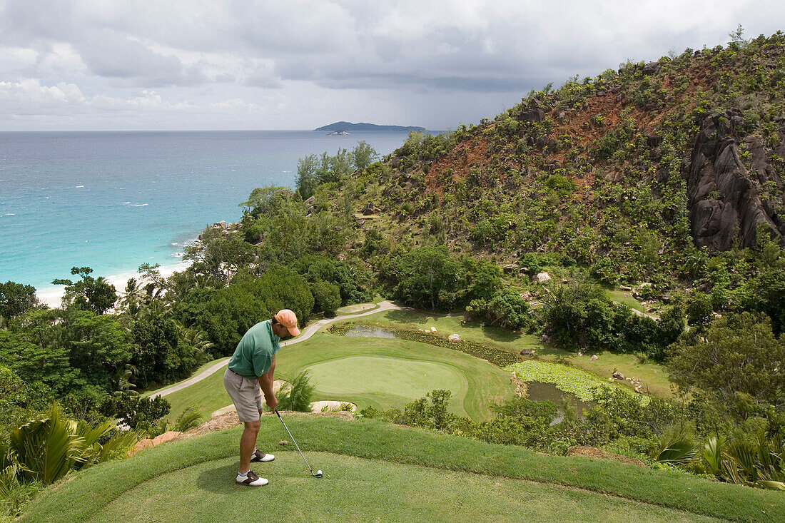Golfer beim Abschlag an Loch 15, Golfplatz, Lemuria Resort auf Praslin, Praslin Island, Seychellen