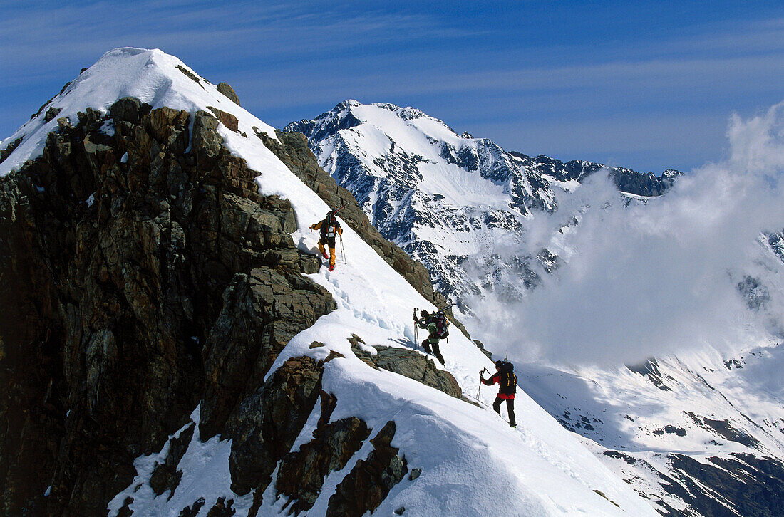 Three people on a skitour to the summit, Stubai, Tyrol, Austria