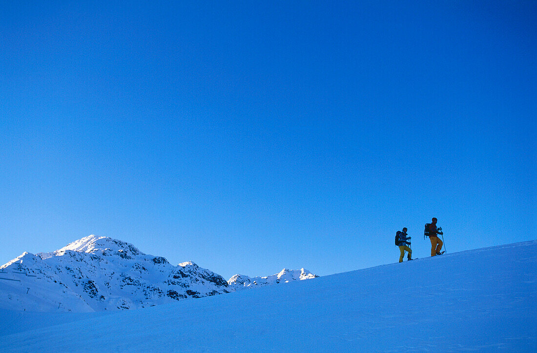 Couple snowshoeing through a winter landscape, Serfaus, Tyrol, Austria